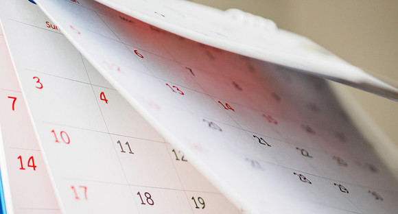 Einfacher Wandkalender, bei dem mehrere Monatsblätter aufgeblättert sind