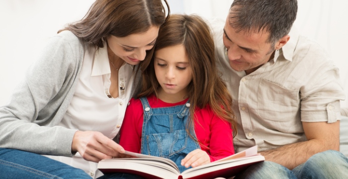 Eltern lesen zusammen mit ihrer Tochter