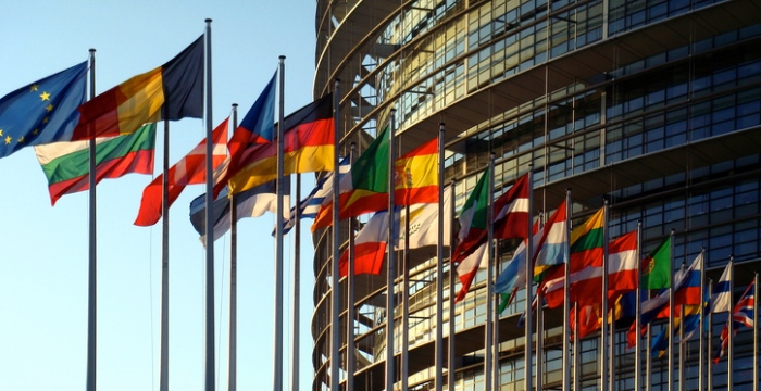 Vor dem Europäische PArlament wehen mehrere Fahnen der Mitgliedsstaatne im Wind. 