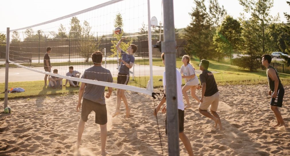 eine Gruppe Menschen spielt gemeinsam Volleyball. 