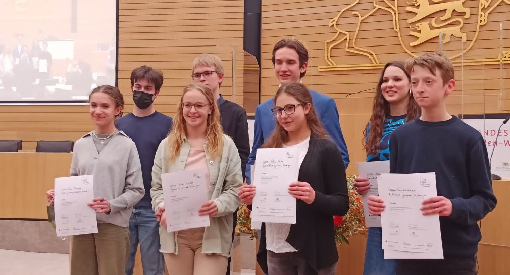 Schülerinnen und Schüler, die beim Landeswettbewerb Jugend debattiert gewonnen haben, zeigen ihre Urkunden.