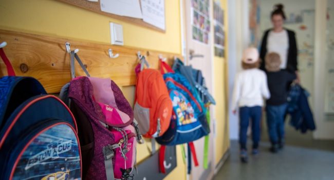 Taschen hängen an einer Garderobe in einem Kindergarten