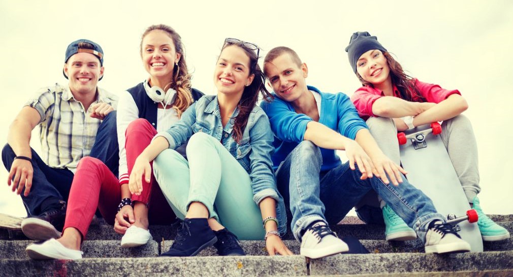 Fünf Jugendliche sitzen nebeneinander auf einer Treppe.  