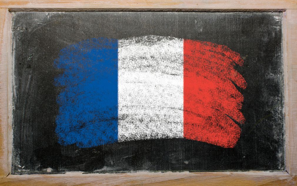 Auf einer Tafel ist die französische Flagge gezeichnet: ein blauer, ein weißer und ein roter senkrechter Balken.  