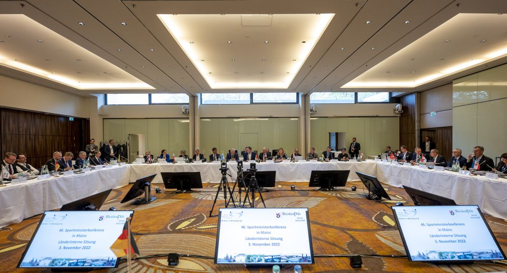 Die Sportministerinnen und -minister der Länder sitzen um einen Tisch bei einer Konferenz in Rheiland-Pfalz